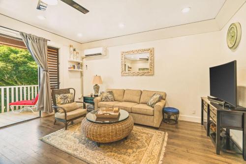 a living room with a couch and a tv at Full Remodeled 1br condo with Air conditioner in Koloa