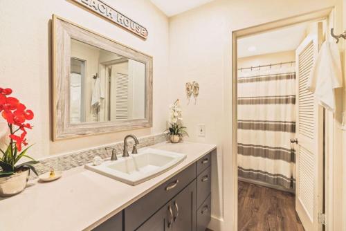 a bathroom with a sink and a mirror and a shower at Full Remodeled 1br condo with Air conditioner in Koloa