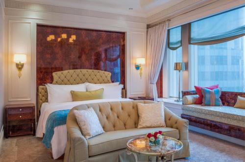 a bedroom with a bed and a couch and a table at The St Regis Singapore in Singapore