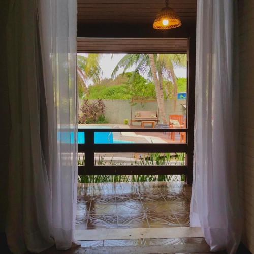 a door to a patio with a view of a pool at Pousada Jardins in Santarém
