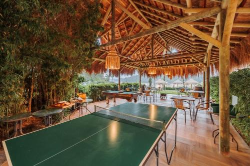 a pool table in a pavilion with tables and chairs at Hotel Pietrasanta in Guatapé