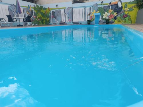 a large swimming pool with blue water in a building at Hotel Iguaçu Centro in Foz do Iguaçu