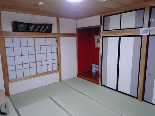 a room with two glass doors and a red wall at ソラリウム小諸 in Komoro