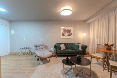 a living room with a green couch and chairs at Hotel Heritage in Sao Paulo