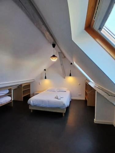 une chambre avec un lit blanc et une grande fenêtre dans l'établissement Appartement T3 - Centre Cambrai, à Cambrai