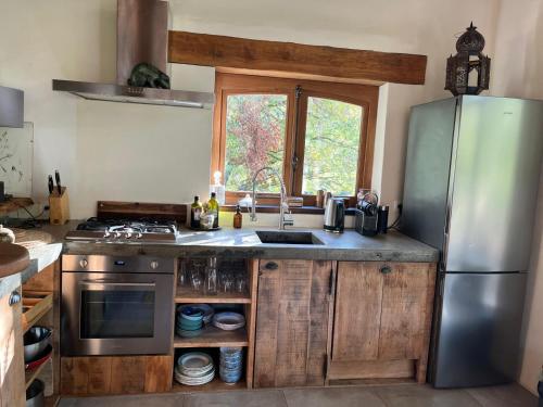 une cuisine avec un réfrigérateur en acier inoxydable et un évier dans l'établissement Lake House I // Alauzet Ecolodge + Nature spa, à Castelnau-de-Mandailles