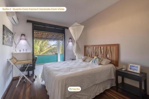 a bedroom with a bed and a desk and a window at Casa Gracinda: piscina ampla e jardim em Fortim in Maceio