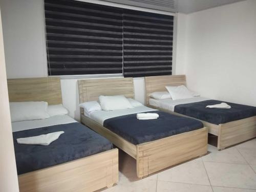 two twin beds in a room with a window at HOTEL GLASS LAS VEGAS in La Vega