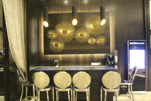 a restaurant with a counter with chairs and mirrors at Geobay Hotel in Johor Bahru