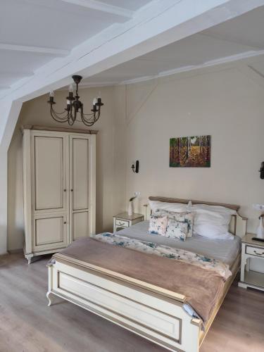 a bedroom with a large bed and a chandelier at Oldtownvilla studio central in Sibiu