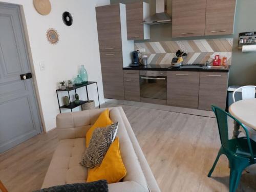 un salon avec un canapé et une cuisine dans l'établissement Au 147 Appartement charmant 2 personnes, à Ligny-en-Barrois
