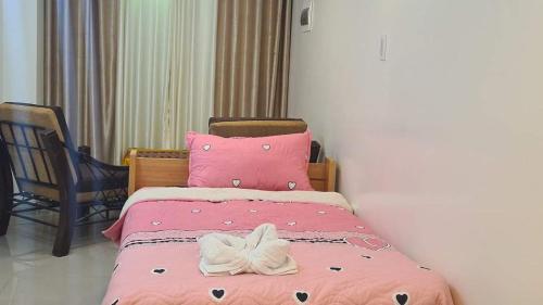 a pink bed with a white bow on top of it at Quechua hospedaje in Huaraz