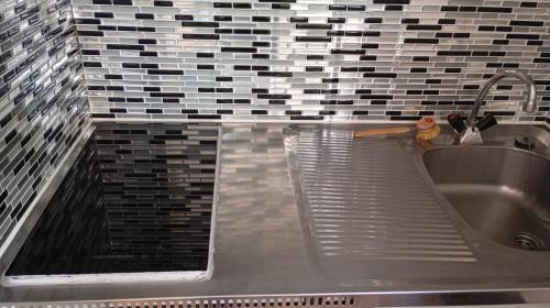 La salle de bains est pourvue d'un lavabo et d'un mur en carrelage. dans l'établissement Studio Plage 200m Parking gratuit Port la Nouvelle, à Port-la-Nouvelle