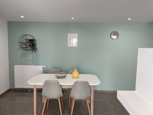 a white table and chairs in a room with a white wall at Maison proche Loire et Châteaux in Meung-sur-Loire