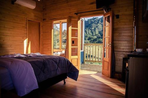 a bedroom with a bed and a large window at Blue Sunset 2 in Urubici