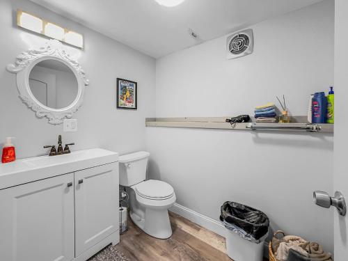 a white bathroom with a toilet and a mirror at Timberline Lodge in Ellicottville