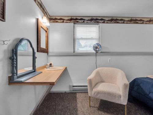 a bathroom with a sink and a chair and a mirror at Timberline Lodge in Ellicottville