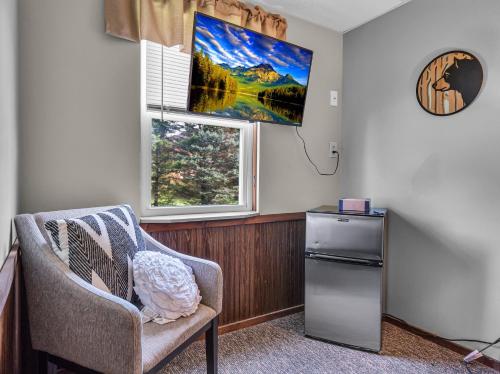 a room with a chair and a window and a refrigerator at Timberline Lodge in Ellicottville