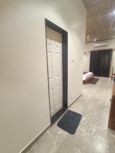 a room with a door with a blue rug on the floor at Shantadurga Beachside Homestay in Guhagar