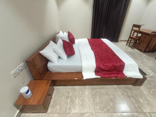 a large bed with red and white sheets and pillows at Shantadurga Beachside Homestay in Guhagar