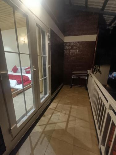 a room with a balcony with a bed and windows at Shantadurga Beachside Homestay in Guhagar