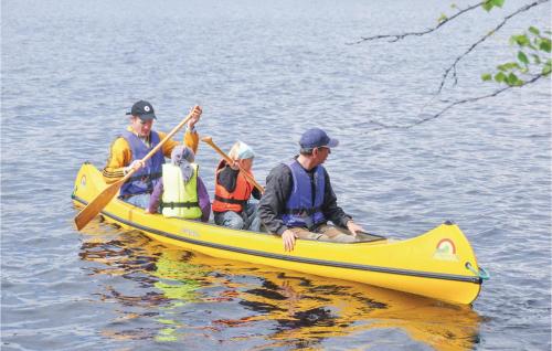 a group of people in a yellow canoe on the water at 1 Bedroom Stunning Home In Fegen in Fegen
