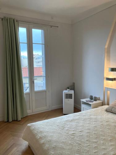une chambre avec un lit et une grande fenêtre dans l'établissement Cannes Centre Apartment 2-Room by Palais des Festivals & Beach, à Cannes