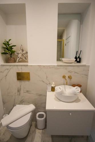 a bathroom with a sink and a toilet and a mirror at SUNRISE 1 Bedroom Apartment in Central Eastbourne in Eastbourne
