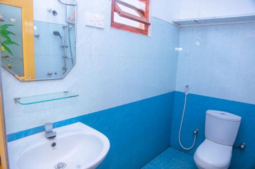 a blue and white bathroom with a sink and a toilet at Blue Sky in Mirissa