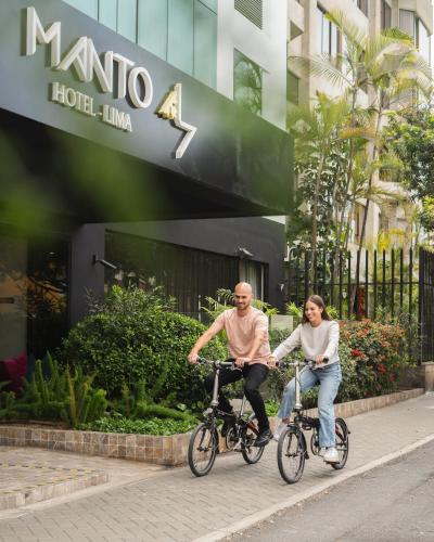 a man and woman riding bikes in front of a hotel at Manto Hotel Lima - MGallery Collection in Lima