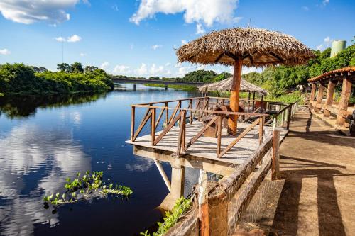 a pier with an umbrella on a river at Hotel Pantanal Mato Grosso in Poconé