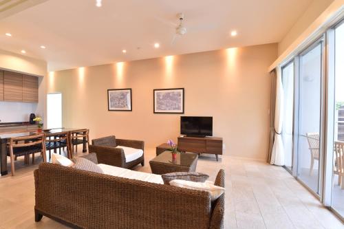 a living room with a couch and a television at Feliz Villa Suite Miyakojima Ueno in Miyako Island