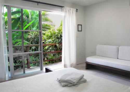 sypialnia z łóżkiem i dużym oknem w obiekcie Elements of the Island w mieście Isla Mujeres