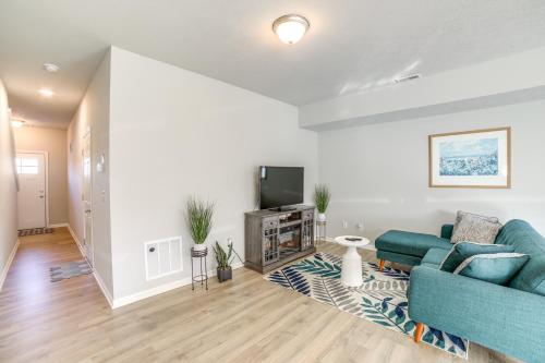 a living room with a blue couch and a tv at 10 Mi to Grand Rapids Modern Townhome! in Kentwood