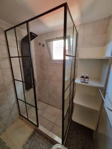 a shower with a glass door in a bathroom at Moderno Duplex 1 - Complejo Las Cerezas in Esquel