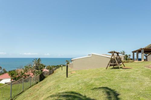a park with a playground and a play structure at Chakas Rock Chalets 15 in Ballito