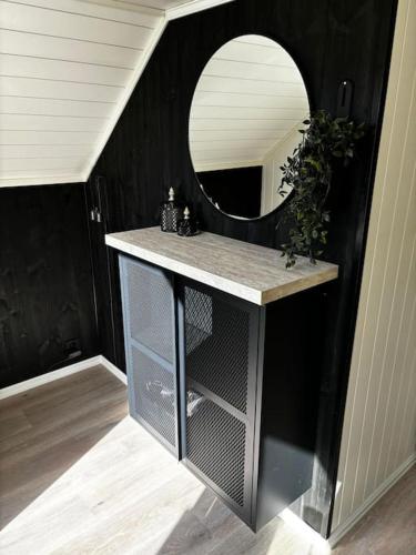 a bathroom with a mirror and a counter with a shelf at NY og moderne studioleilighet med elbil lading in Gjøvik