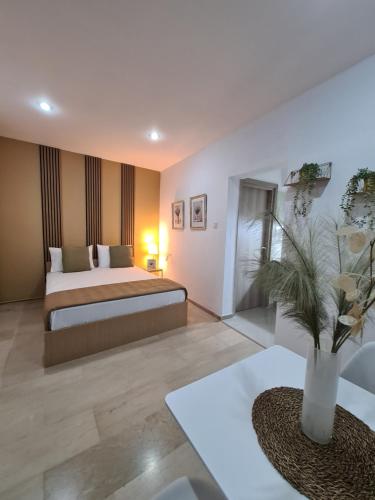 ein Schlafzimmer mit einem Bett und einem Tisch mit einer Vase in der Unterkunft Apartment in the heart of the city 5G in Larisa