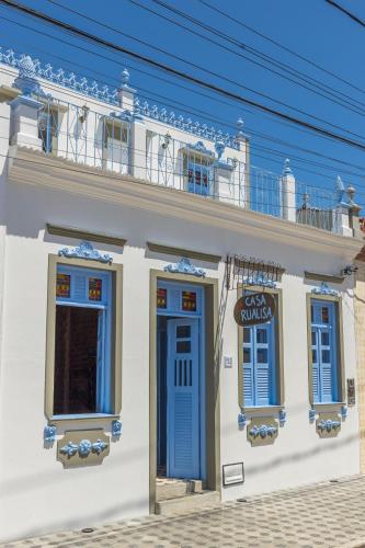 a white building with blue doors and a balcony at Casa Rualisa in Belmonte