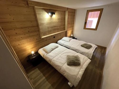 deux lits dans une chambre aux murs en bois dans l'établissement Apartment Belle Vue, à Les Coches