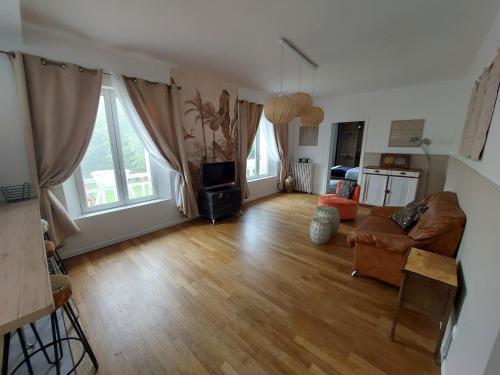 a living room with a couch and a tv at La Maisonnée in Marolles