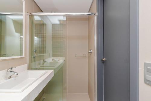 a bathroom with a sink and a shower at Edifício Helbor Stay - Batel | Gonzaga Stays in Curitiba