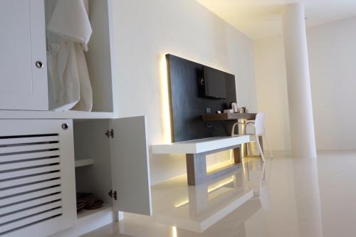 a white room with a desk and a tv at Hotel Chuan Chom The High Resort Saraburi - SHA Plus in Sara Buri