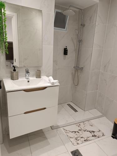 a white bathroom with a shower and a sink at Tatiana's Town Studio in Corfu
