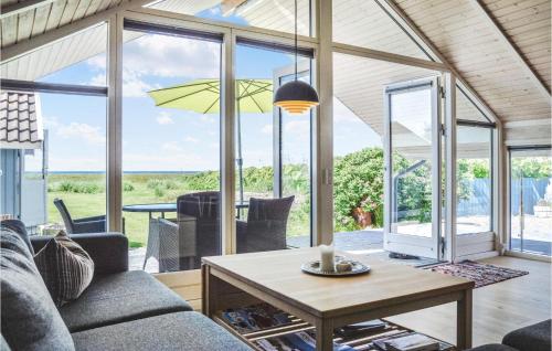 a living room with a couch and a table at Holiday Home Ørnevej Sjællands Odde Denm in Yderby
