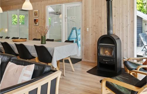 a fireplace in a living room with a table and chairs at Awesome Home In Dannemare With Sauna in Dannemare