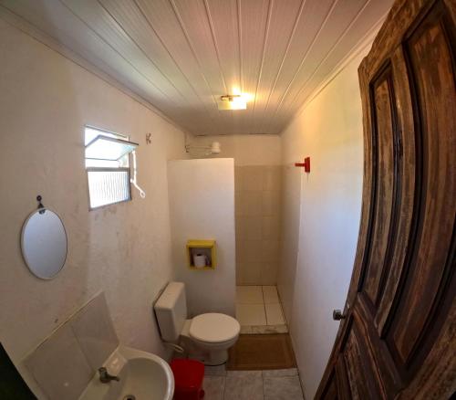 a small bathroom with a toilet and a sink at Hostel Cajueiro in Ilha de Boipeba