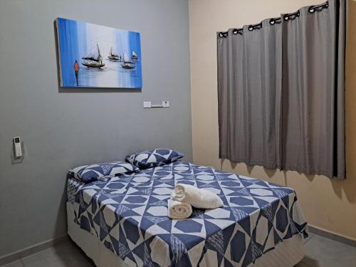 a bedroom with a bed with a blue and white comforter at Casa do Mar & Ane Ilhabela in Ilhabela