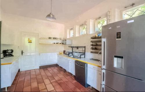 Il comprend une grande cuisine avec des comptoirs blancs et un réfrigérateur. dans l'établissement Awesome Home In Vianne, à Vianne