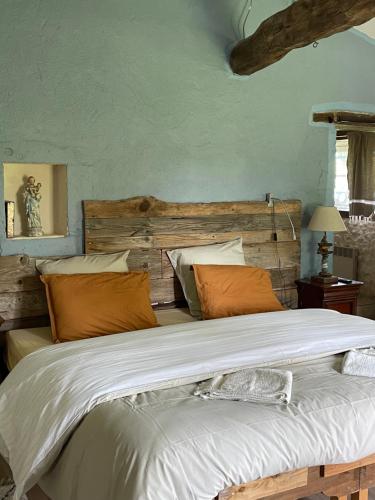 a bedroom with a large bed with orange pillows at Chambre 35 m2 spacieuse calme avec piscine Sud Charente in Bardenac